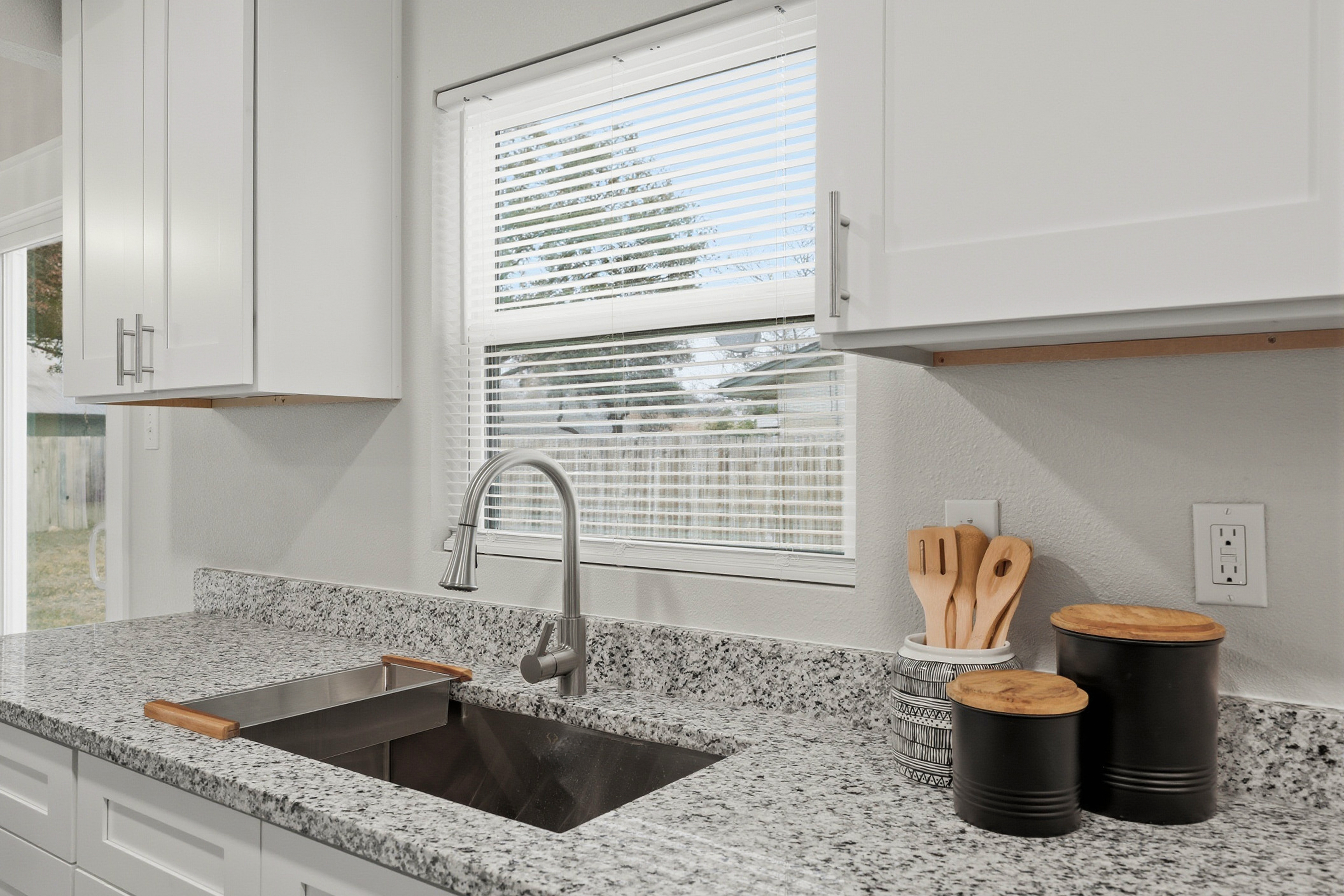 Undermount kitchen sink with modern faucet and granite countertop close-up